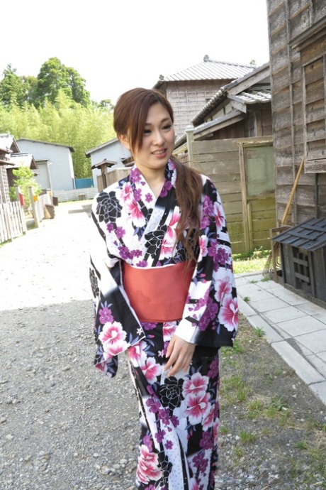 Asian brunette Maki Horiguchi doffs her robe and eats a cock outdoors