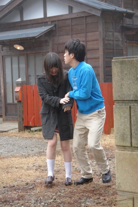 Asian honey Mai Shimizu kneels in front of a guy and gives head outdoors