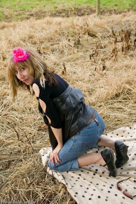 Mature blonde Lizzy strips fully naked and shows off her hairy pussy outdoors