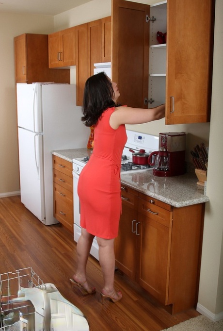 Brunette MILF Iris does a sexy striptease while doing housework