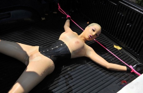 穿着乳胶的英国女孩 在 BDSM 中，乳胶露西被绑在卡车上并被喷水
