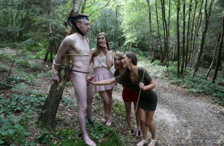 Skinny Tina Kay & her clothed pals jack off a tied up man's cock in the woods - pornpics.de