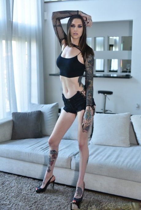 Tall brunette Rocky Emerson uses her sexy tattooed feet to wank a cock
