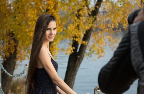 Beautiful Russian teen Leona Mia	poses and goes topless at the park