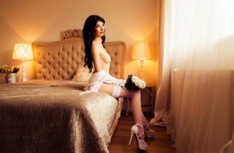 Sweet Romanian babe Allycya Silk reveals her slim figure on a bed