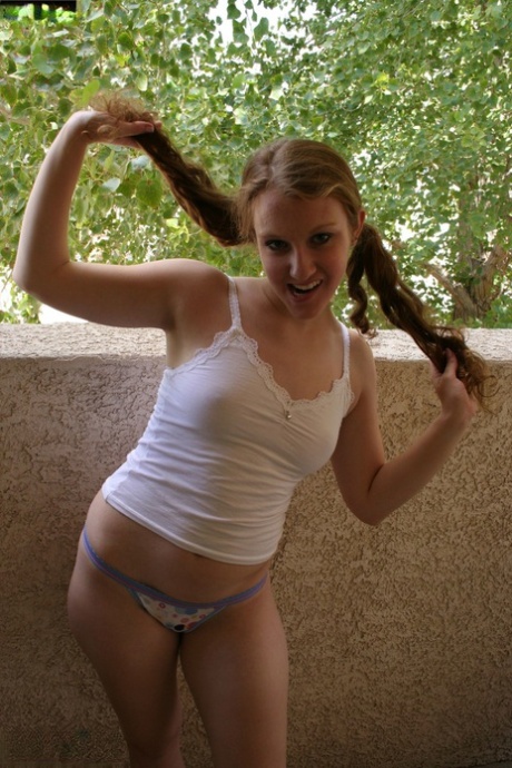 Amateur babe grabs her pigtails while posing in her shirt and panties
