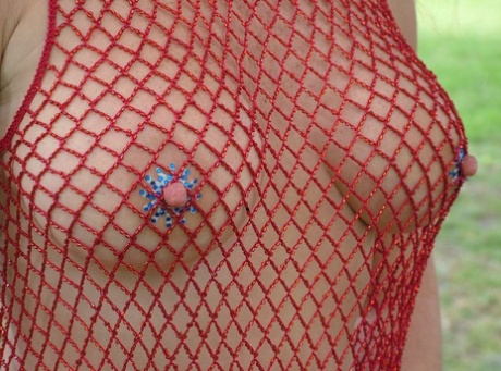 Redheaded MILF with nice boobs rubs her clam in fishnets in a park - pornpics.de