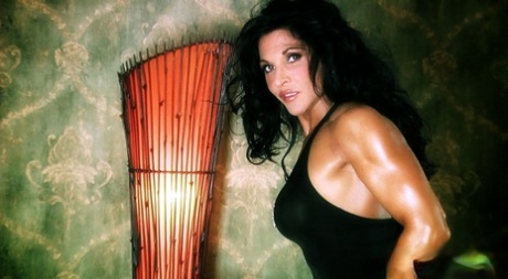 Dark haired bodybuilder Tracy Daniels shows her hot legs in a solo