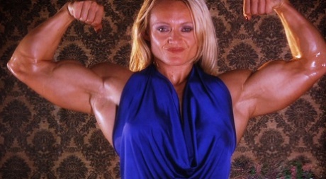 Mature bodybuilder Brigita Brezovac flexing her big muscles in a blue dress