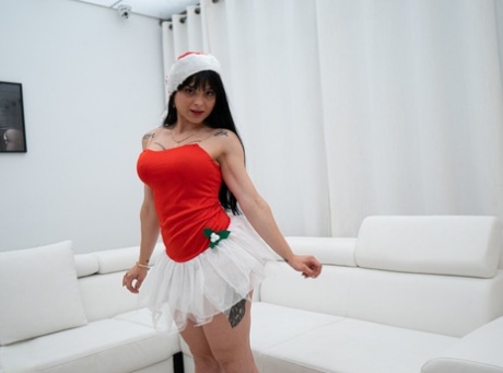 古怪的黑色头发的青少年在圣诞节帽Nadja Lapiedra表示她的大赃物