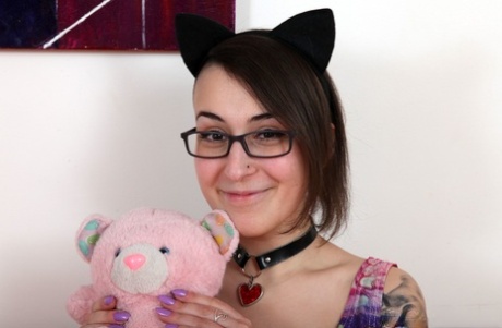 Inked babe in glasses and with cat ears Irogenia poses with a plug in her ass