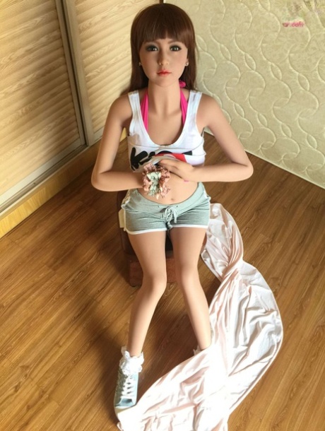漂亮娇小的性爱娃娃穿着运动鞋挑逗时露出中等大小的乳房