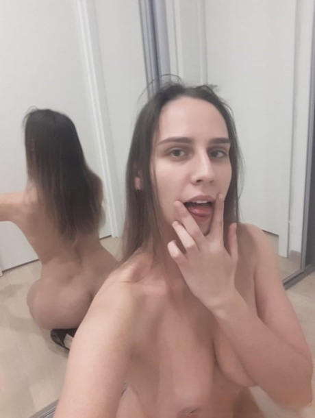 顽皮的业余宝贝对着镜子摆出裸体姿势，展示多汁的乳房