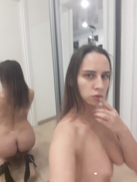 顽皮的业余宝贝对着镜子摆出裸体姿势，展示多汁的乳房