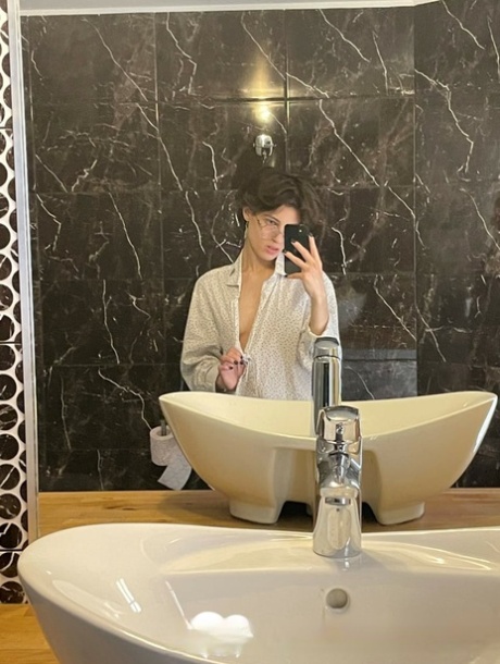 业余的黑发女孩在眼镜炫耀她的小奶子和热腹肌