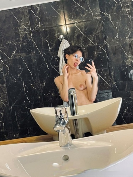 业余的黑发女孩在眼镜炫耀她的小奶子和热腹肌