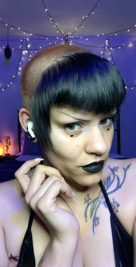 黑发怪异的 Goth Booty 小姐穿着鱼网袜和靴子展示她的大屁股