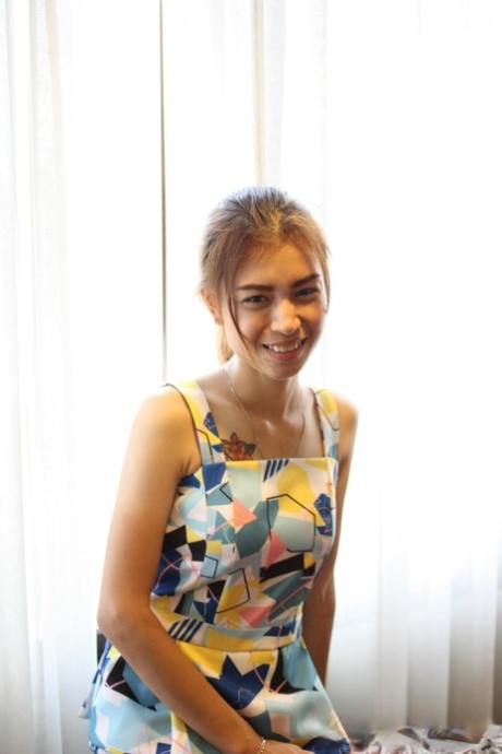 色情亚洲美女条她多彩的衣服和姿势在她的粉红色内衣