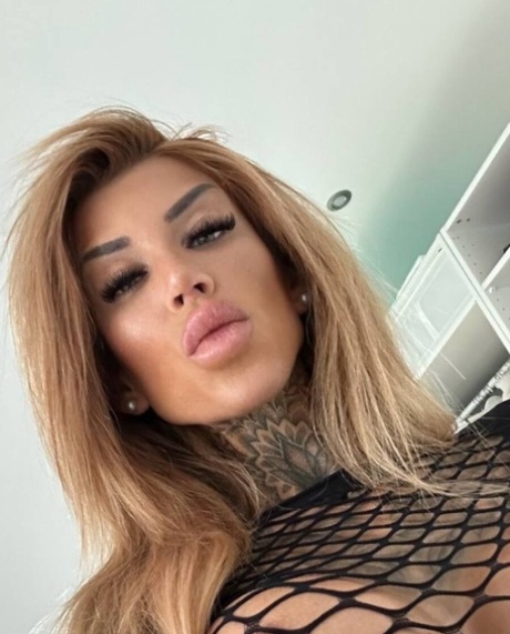 纹身美女穿着迷人的蕾丝内衣摆姿势