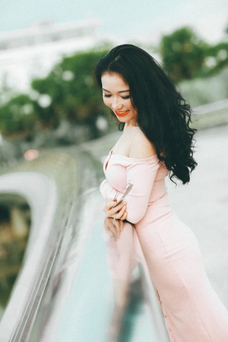 穿着优雅礼服的迷人亚洲美女在她的合辑中摆姿势
