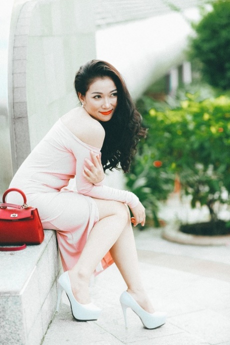 穿着优雅礼服的迷人亚洲美女在她的合辑中摆姿势