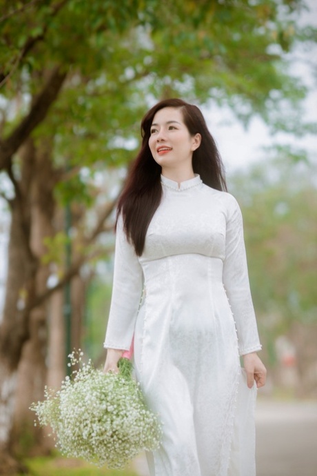 令人惊叹的亚洲模特身着性感连衣裙在公共场合独自摆姿势