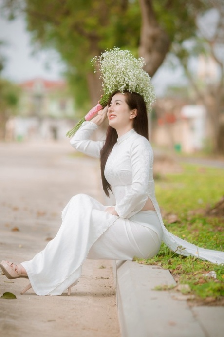 令人惊叹的亚洲模特身着性感连衣裙在公共场合独自摆姿势