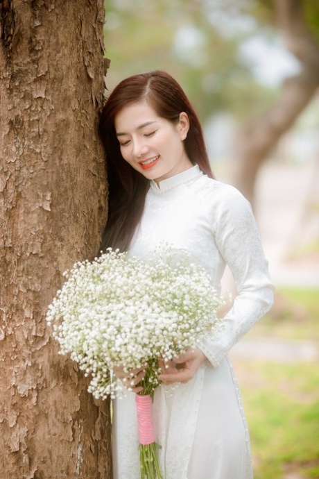 令人惊叹的亚洲模特身着性感连衣裙在公共场合独自摆姿势