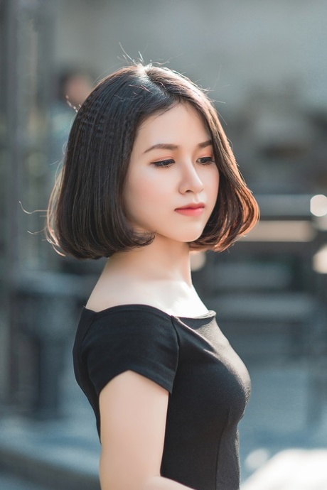 魅力四射的亚洲美女穿着优雅的黑色连衣裙在公共场合搔首弄姿