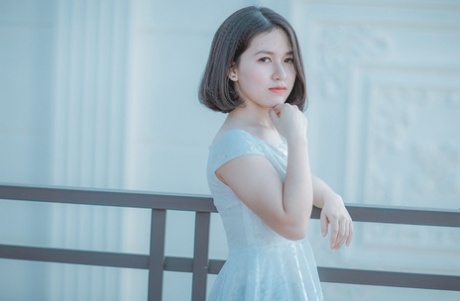 魅力四射的亚洲美女穿着优雅的黑色连衣裙在公共场合搔首弄姿