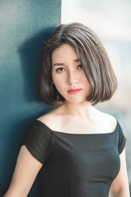 魅力四射的亚洲美女穿着优雅的黑色连衣裙在公共场合搔首弄姿
