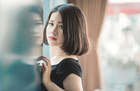 魅力四射的亚洲美女穿着优雅的黑色连衣裙在公共场合搔首弄姿