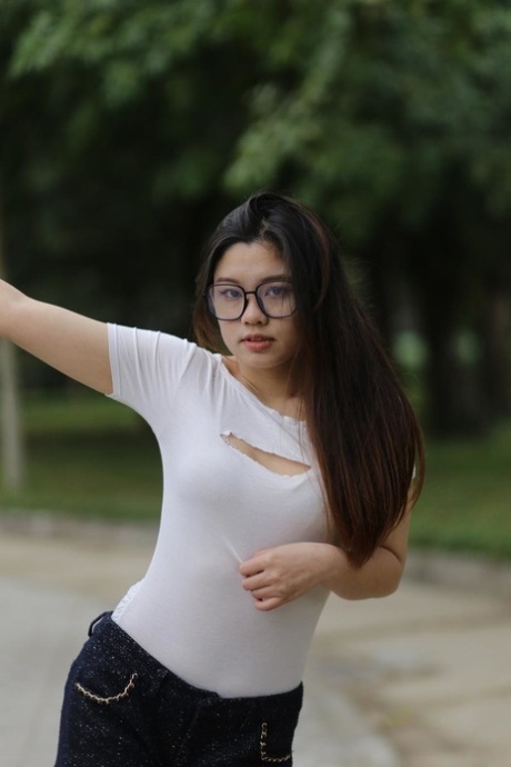 Nerdy Asian model Natalia posing in her sexy tight outfit outdoors
