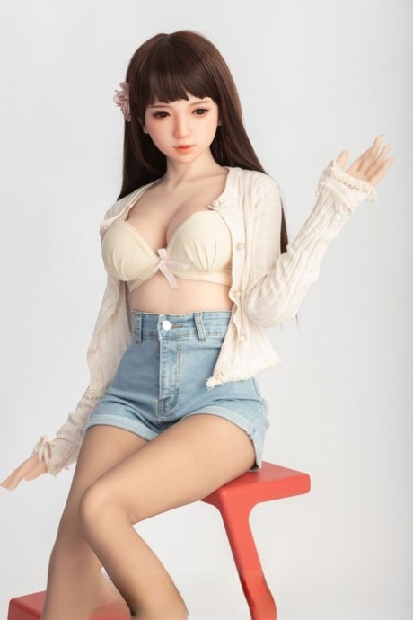 Small sex doll Leonora posing in her white bra and jean shorts in a solo