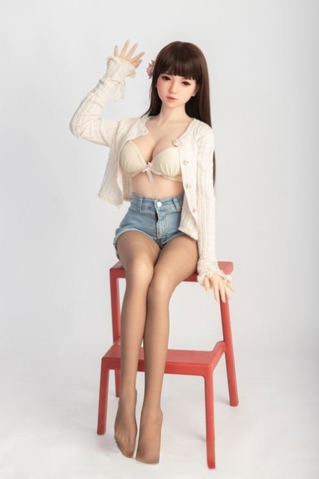 Small sex doll Leonora posing in her white bra and jean shorts in a solo