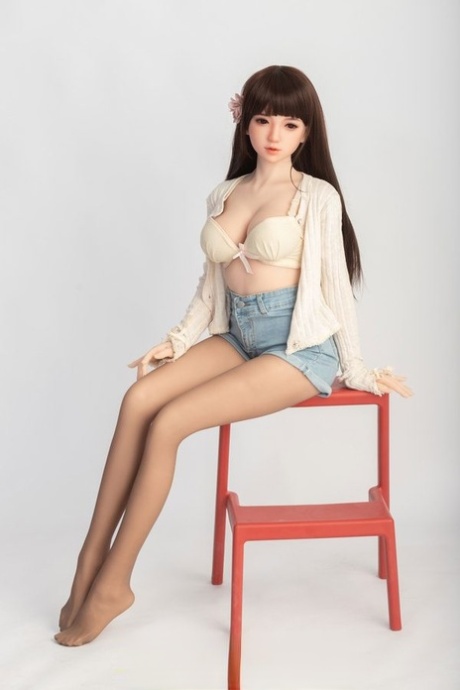 Small sex doll Leonora posing in her white bra and jean shorts in a solo