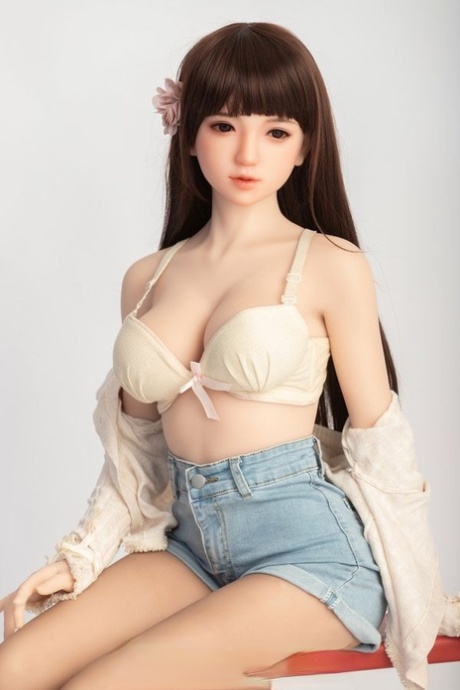 Small sex doll Leonora posing in her white bra and jean shorts in a solo