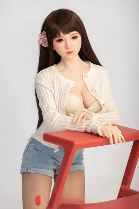 Small sex doll Leonora posing in her white bra and jean shorts in a solo