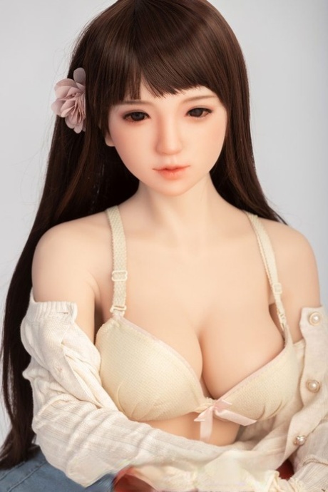 Small sex doll Leonora posing in her white bra and jean shorts in a solo