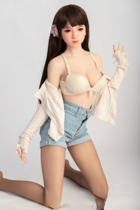 Small sex doll Leonora posing in her white bra and jean shorts in a solo