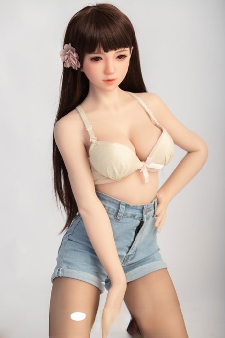 Small sex doll Leonora posing in her white bra and jean shorts in a solo