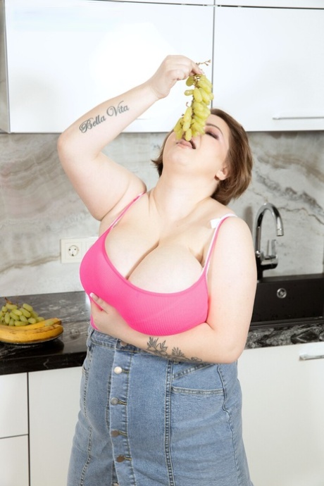 Chubby brunette Mary Brown unleashes her big tits while eating a banana