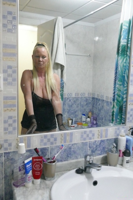 Kinky blonde mature Natalie K spreads her ass cheeks and shows her big tits