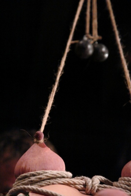 Kinky babe LieLani gets her big nips rope tied and tugged hard on a BDSM wheel