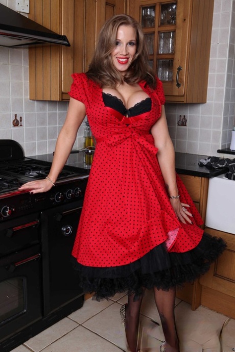 Busty housewife Rebecca More strips to her lingerie & poses in the kitchen